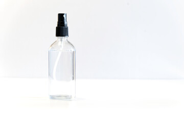 Small glass bottle with spray cap on bright background
