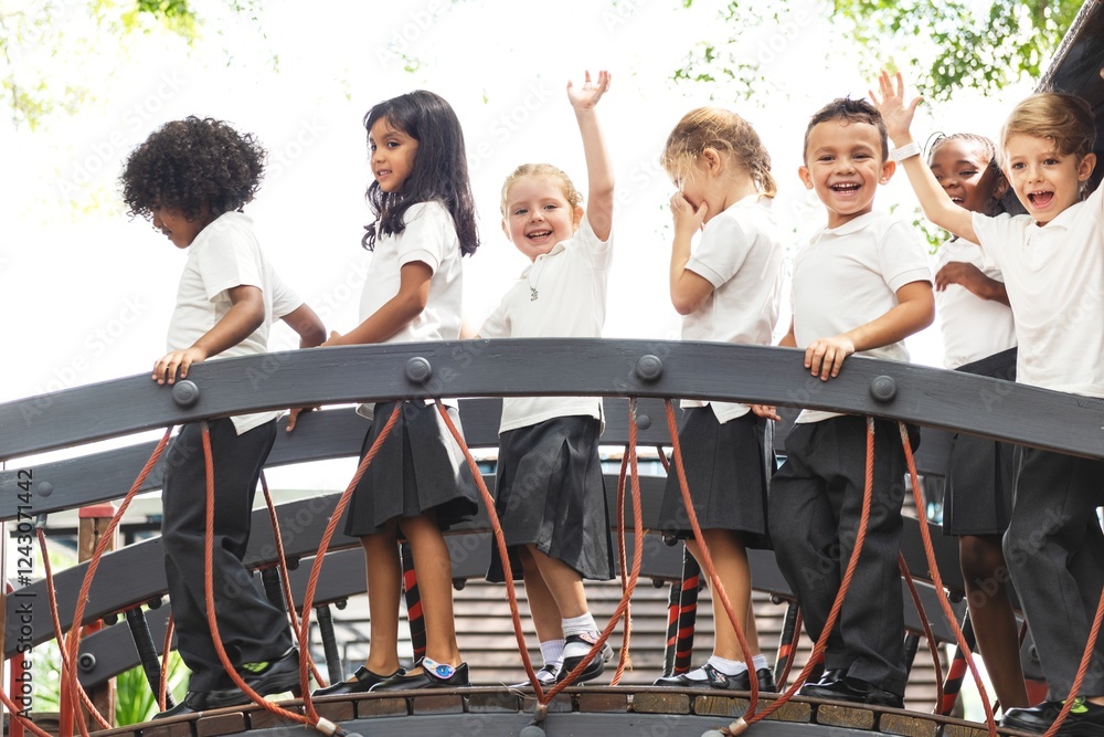 Poster Group of diverse elementary students in school uniforms on a bridge in a playground, smiling and waving. Diverse elementary students in uniforms enjoying a sunny day outdoor activity.