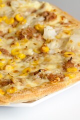 Closeup shot of a pizza made of corn on a white table