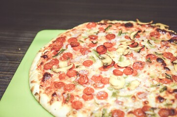 Closeup shot of a pizza with mushrooms on a green plate