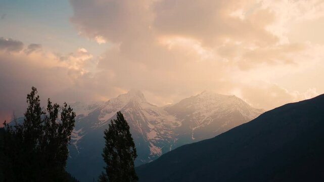 4K Clouds above the snowy mountains during the sunset as seen from Keylong in Himachal Pradesh, India during the autumn season. Clouds above snowy Himalayas in autumn season with little snow on peaks.