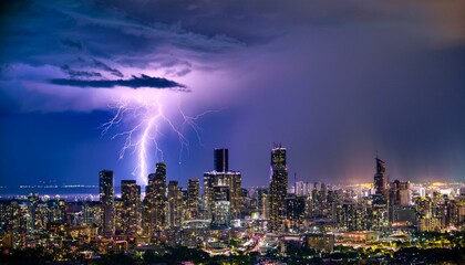 A breathtaking spectacle unfolds as a powerful lightning storm electrifies the night sky over a sprawling cityscape, casting an eerie yet mesmerizing purple glow.