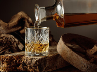 Whiskey is poured from a decanter into a glass.