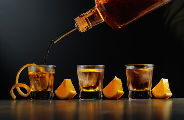 Old-fashioned cocktail with ice and orange.