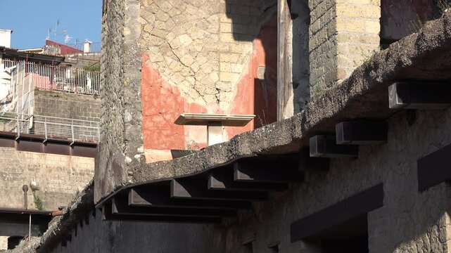 Exposed table on first floor of ancient Roman house, contrasting with modern buildings, in Herculaneum, Italy
