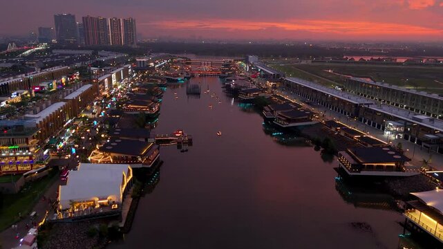 Batavia PIK 2 at sunset with the floating restaurant over the sea canal filled with life and lights