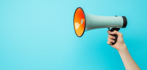 Hand holds megaphone, blue background, announcement