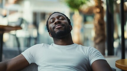 Obraz premium African American man relaxing outdoors. Ideal for wellness lifestyle, peaceful moments, and authentic joy content.
