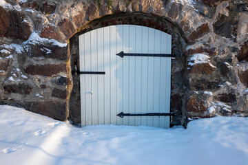 Old wooden door locked with padlock in wintertime