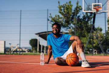 Fototapeta premium Basketball player relaxing after training on outdoor court