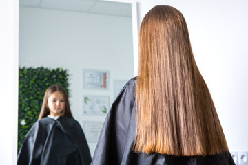 Adorable Little Girl Enjoying Her First Haircut in a Beauty Salon.