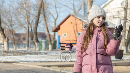 little girl playing on the playground on a winter day