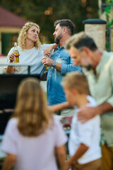 Family having a barbecue party and talking in the backyard