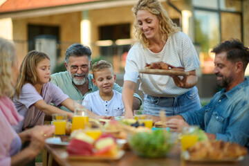 Happy family having lunch together outdoors on a sunny day