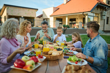 Happy extended family having lunch in the backyard