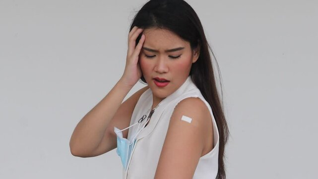 Unhealthy Asian woman getting vaccinated immunity with muscle pain, concept of inoculation, vaccination, side effects of vaccine, inoculating coronavirus antibody response with undesirable side effect