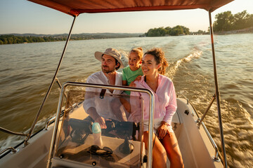 Happy family enjoying a relaxing speedboat ride on a picturesque lake at sunset, creating lasting...