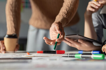 Team discussing UX UI strategies with sketches and digital tools in a workspace.
