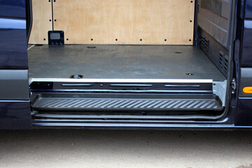 Side door open in cargo van. Floor and step of a cargo van. Cargo van trunk open. Van trunk with...