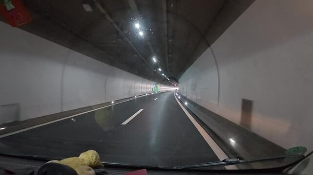 Driving through a tunnel on a road trip in Switzerland from Brunnen to Melide, sunny Ticino