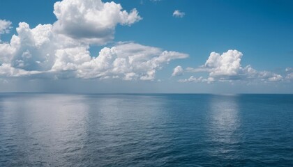 Obraz premium A calm ocean with blue water and white clouds in the sky