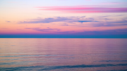 Obraz premium Serene Dawn Seascape with Soft Pink, Purple, and Blue Sky, Wispy Clouds, Tranquil Ocean Reflection, Gentle Waves, Clear Horizon, Peaceful Coastal Atmosphere, High-Resolution Scenic Background 