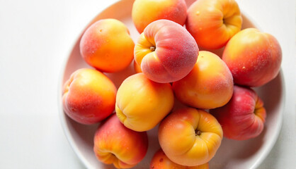 Platter of ripe apricots with visible fuzz on a white background with copy space