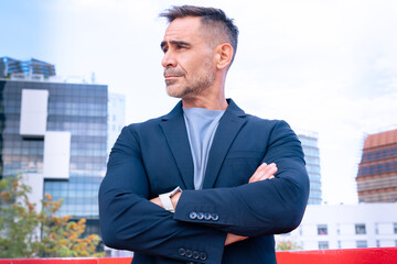 Confident Businessman Standing with Arms Crossed in Urban Setting