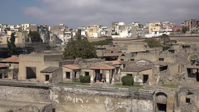 Remains of houses in Herculaneum village contrast with new homes of Ercolano town, history and tourism Italy
