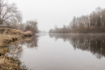 Foggy Riverbank with Still Water Reflection – Tranquil Winter Landscape