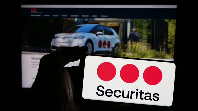 Stuttgart, Germany - 01-29-2025: Person holding mobile phone with logo of Swedish security service company Securitas AB on screen in front of web page. Focus on phone display.
