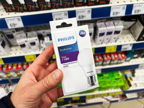 Kyiv, Ukraine - February 04, 2025: Person holding Philips LED light bulb package in a store shopping scenario