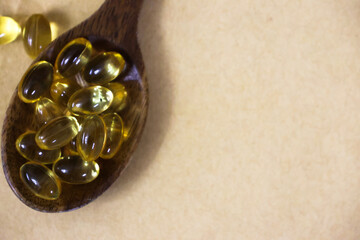 Omega 3 capsules in the wooden spoon. Cod liver oil capsules on the table. Healthy life style concept