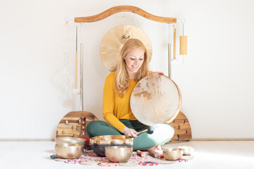 Young cheerful woman performing music therapy session with traditional instruments. Sound...