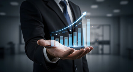 Businessman Presenting Growing Graph in Modern Office. A businessman in a suit holds a holographic bar graph, showcasing upward growth