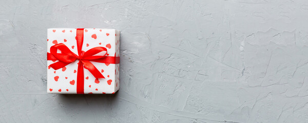 Valentine day composition: red gift box with bow and heart. Christmas present. View from above....