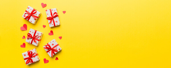 Valentine day composition: red gift box with bow and heart. Christmas present. View from above. Space for text. Holday greeting card