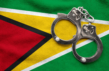 Flag of Guyana and police handcuffs. Crime and offenses in country Concept
