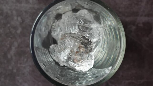 Pour fall ice cubes in empty glass. Throw ice cubes, Top view