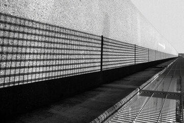 Urban black and white landscape. Silhouette of a fence. Inverted image. Conceptual image. Graphic composition. Perspective.