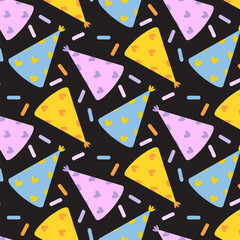 Colorful party hats with hearts and sprinkles on a black background for festive celebrations