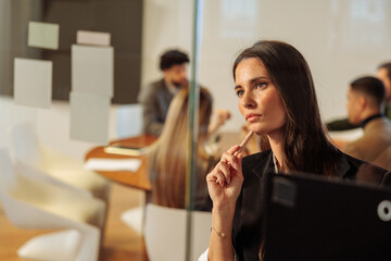 Beautiful female employee looking at her notes on the door