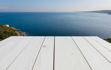 A close-up of a white wooden table with a view of the ocean in the background.