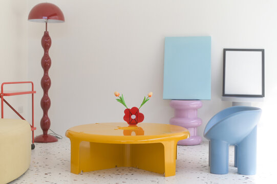 Bright and colorful interior featuring yellow coffee table, red lamp, and decorative elements. playful and modern design aesthetic