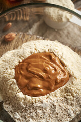 Whey protein powder, ground oat flakes and nut butter in a bowl - ingredients for homemade protein bars