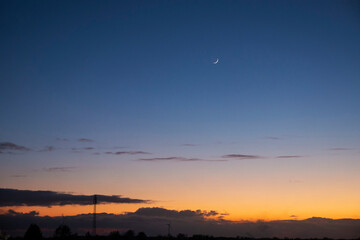 The sunset paints the sky with a stunning blend of blue and orange, fading into deep night hues. A breathtaking view that soothes the soul with its calming and mesmerizing colors.