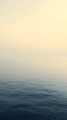 A serene view of calm ocean waters blending seamlessly with a pastel sky during twilight. The tranquil setting evokes feelings of peace and solitude.