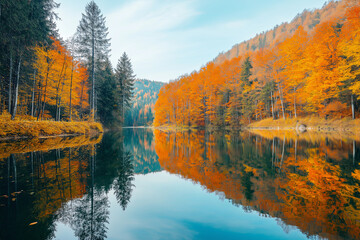 Obraz premium A perfectly symmetrical, mirrored lake surrounded by autumn-colored trees