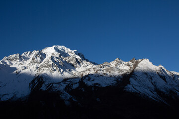 Obraz premium A mountain covered in snow with a cloud in the sky