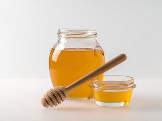 Natural organic honey in glass jar, honey dipper and honeycombs are near. Natural food background.